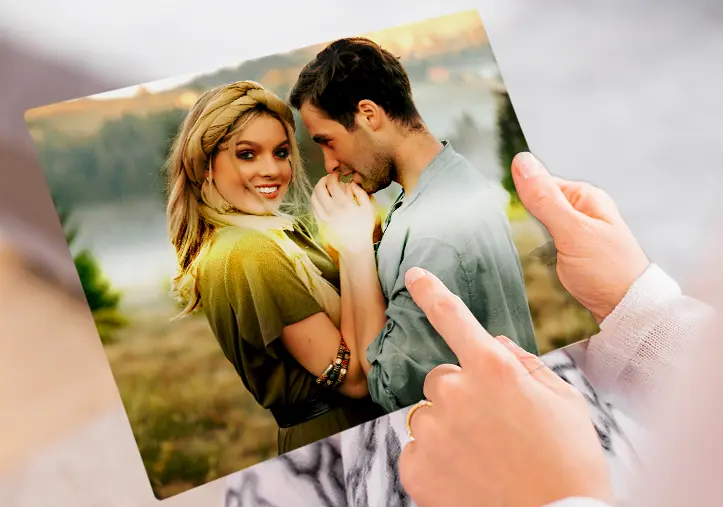 A metal print on a wall with a landscape shot; a small metal print of two dogs