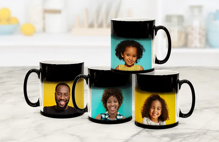 Magic Mug|Three mugs, being filled with hot water to reveal a baby.|Young boy holding custom designed magic mug with photo of himself on|Magic mug with picture of cat on having tea poured into it on desk|Couple holding two heat changing magic mugs with custom text by Printerpix|Three mugs: one empty (blank), one half full (half an image) and one full (full image)|Grandad and grand daughter holding hands with personalised mug with photo of grand daughter||||